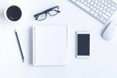 Bilgisayarlı beyaz masa ofisi, akıllı telefon ve bir fincan kahveli diğer iş malzemeleri. Metni kopyalamak için üst görünümü kullan. Desenci çalışma alanı düz masa üzerinde temel elementler yatıyordu.