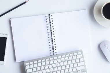 Bilgisayarlı beyaz masa ofisi, akıllı telefon ve bir fincan kahveli diğer iş malzemeleri. Metni kopyalamak için üst görünümü kullan. Desenci çalışma alanı düz masa üzerinde temel elementler yatıyordu.