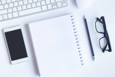 Bilgisayarlı beyaz masa ofisi, akıllı telefon ve bir fincan kahveli diğer iş malzemeleri. Metni kopyalamak için üst görünümü kullan. Desenci çalışma alanı düz masa üzerinde temel elementler yatıyordu.