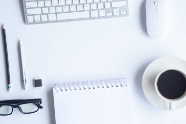Bilgisayarlı beyaz masa ofisi, akıllı telefon ve bir fincan kahveli diğer iş malzemeleri. Metni kopyalamak için üst görünümü kullan. Desenci çalışma alanı düz masa üzerinde temel elementler yatıyordu.