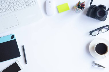 Bilgisayarlı beyaz masa ofisi, akıllı telefon ve bir fincan kahveli diğer iş malzemeleri. Metni kopyalamak için üst görünümü kullan. Desenci çalışma alanı düz masa üzerinde temel elementler yatıyordu.