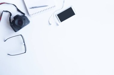 Bilgisayarlı beyaz masa ofisi, akıllı telefon ve bir fincan kahveli diğer iş malzemeleri. Metni kopyalamak için üst görünümü kullan. Desenci çalışma alanı düz masa üzerinde temel elementler yatıyordu.