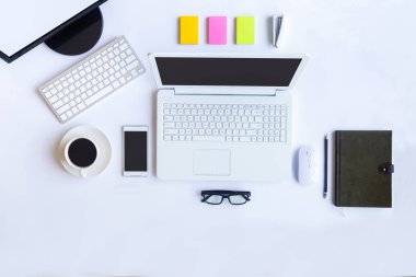 Bilgisayarlı beyaz masa ofisi, akıllı telefon ve bir fincan kahveli diğer iş malzemeleri. Metni kopyalamak için üst görünümü kullan. Desenci çalışma alanı düz masa üzerinde temel elementler yatıyordu.