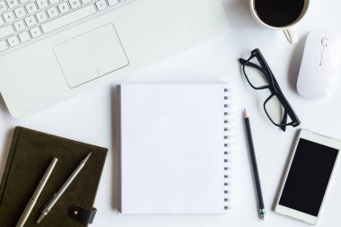 Bilgisayarlı beyaz masa ofisi, akıllı telefon ve bir fincan kahveli diğer iş malzemeleri. Metni kopyalamak için üst görünümü kullan. Desenci çalışma alanı düz masa üzerinde temel elementler yatıyordu.