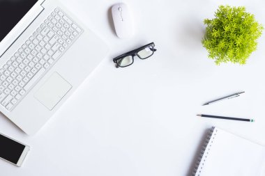 Bilgisayarlı beyaz masa ofisi, akıllı telefon ve bir fincan kahveli diğer iş malzemeleri. Metni kopyalamak için üst görünümü kullan. Desenci çalışma alanı düz masa üzerinde temel elementler yatıyordu.