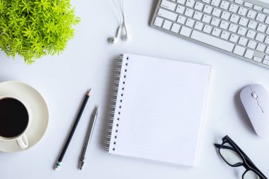 Bilgisayarlı beyaz masa ofisi, akıllı telefon ve bir fincan kahveli diğer iş malzemeleri. Metni kopyalamak için üst görünümü kullan. Desenci çalışma alanı düz masa üzerinde temel elementler yatıyordu.