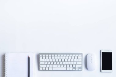 Bilgisayarlı beyaz masa ofisi, akıllı telefon ve bir fincan kahveli diğer iş malzemeleri. Metni kopyalamak için üst görünümü kullan. Desenci çalışma alanı düz masa üzerinde temel elementler yatıyordu.