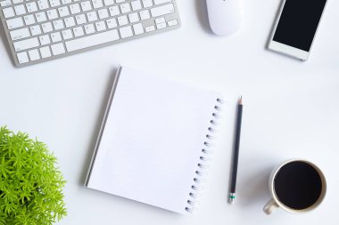 Bilgisayarlı beyaz masa ofisi, akıllı telefon ve bir fincan kahveli diğer iş malzemeleri. Metni kopyalamak için üst görünümü kullan. Desenci çalışma alanı düz masa üzerinde temel elementler yatıyordu.