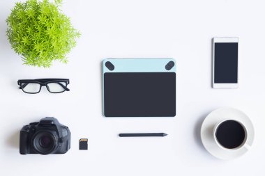 Bilgisayarlı beyaz masa ofisi, akıllı telefon ve bir fincan kahveli diğer iş malzemeleri. Metni kopyalamak için üst görünümü kullan. Desenci çalışma alanı düz masa üzerinde temel elementler yatıyordu.