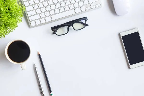 White desk office with laptop, smartphone and other work supplies with cup of coffee. Top view with copy space for input the text. Designer workspace on desk table essential elements on flat lay.