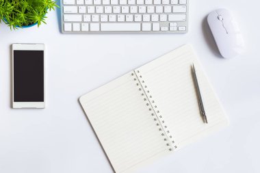 Bilgisayarlı beyaz masa ofisi, akıllı telefon ve bir fincan kahveli diğer iş malzemeleri. Metni kopyalamak için üst görünümü kullan. Desenci çalışma alanı düz masa üzerinde temel elementler yatıyordu.