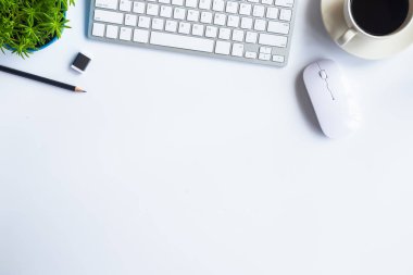 Bilgisayarlı beyaz masa ofisi, akıllı telefon ve bir fincan kahveli diğer iş malzemeleri. Metni kopyalamak için üst görünümü kullan. Desenci çalışma alanı düz masa üzerinde temel elementler yatıyordu.