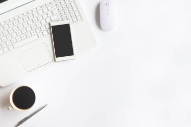 Bilgisayarlı beyaz masa ofisi, akıllı telefon ve bir fincan kahveli diğer iş malzemeleri. Metni kopyalamak için üst görünümü kullan. Desenci çalışma alanı düz masa üzerinde temel elementler yatıyordu.
