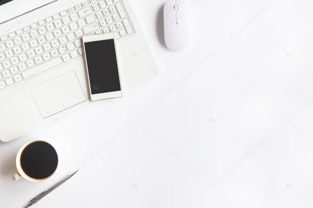 White desk office with laptop, smartphone and other work supplies with cup of coffee. Top view with copy space for input the text. Designer workspace on desk table essential elements on flat lay.