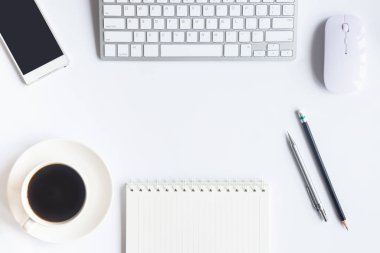 Bilgisayarlı beyaz masa ofisi, akıllı telefon ve bir fincan kahveli diğer iş malzemeleri. Metni kopyalamak için üst görünümü kullan. Desenci çalışma alanı düz masa üzerinde temel elementler yatıyordu.