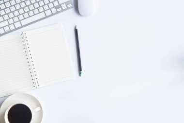 Bilgisayarlı beyaz masa ofisi, akıllı telefon ve bir fincan kahveli diğer iş malzemeleri. Metni kopyalamak için üst görünümü kullan. Desenci çalışma alanı düz masa üzerinde temel elementler yatıyordu.