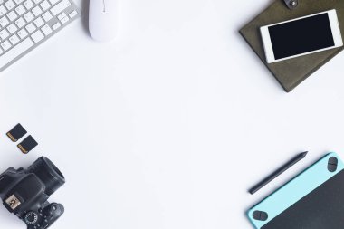 Bilgisayarlı beyaz masa ofisi, akıllı telefon ve bir fincan kahveli diğer iş malzemeleri. Metni kopyalamak için üst görünümü kullan. Desenci çalışma alanı düz masa üzerinde temel elementler yatıyordu.