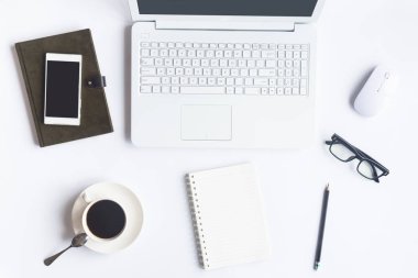 Bilgisayarlı beyaz masa ofisi, akıllı telefon ve bir fincan kahveli diğer iş malzemeleri. Metni kopyalamak için üst görünümü kullan. Desenci çalışma alanı düz masa üzerinde temel elementler yatıyordu.