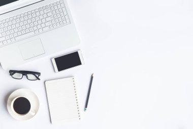 Bilgisayarlı beyaz masa ofisi, akıllı telefon ve bir fincan kahveli diğer iş malzemeleri. Metni kopyalamak için üst görünümü kullan. Desenci çalışma alanı düz masa üzerinde temel elementler yatıyordu.