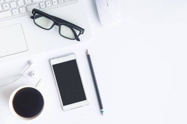 Bilgisayarlı beyaz masa ofisi, akıllı telefon ve bir fincan kahveli diğer iş malzemeleri. Metni kopyalamak için üst görünümü kullan. Desenci çalışma alanı düz masa üzerinde temel elementler yatıyordu.