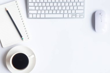 Bilgisayarlı beyaz masa ofisi, akıllı telefon ve bir fincan kahveli diğer iş malzemeleri. Metni kopyalamak için üst görünümü kullan. Desenci çalışma alanı düz masa üzerinde temel elementler yatıyordu.