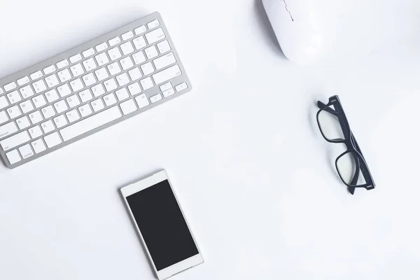 White desk office with laptop, smartphone and other work supplies with cup of coffee. Top view with copy space for input the text. Designer workspace on desk table essential elements on flat lay.