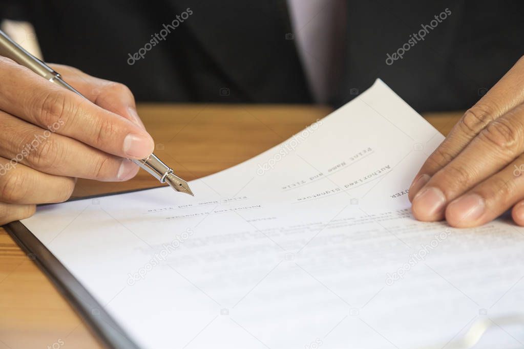 Business man signing a contract. Owns the business sign personally,director of the company, solicitor. Real estate agent holding house, moving home or renting property, merger and acquisition concept.