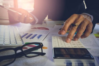 İşadamı veya iş veri kavramı hesaplamak için hesap makinesi üzerinde çalışmaya muhasebeci. Muhasebe, mali rapor durumuna danışmanlık ve planlama ofisinde bir pazarlama planı yatırım danışmanı.