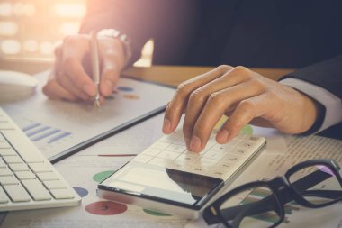 İşadamı veya iş veri kavramı hesaplamak için hesap makinesi üzerinde çalışmaya muhasebeci. Muhasebe, mali rapor durumuna danışmanlık ve planlama ofisinde bir pazarlama planı yatırım danışmanı.