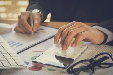 İşadamı veya iş veri kavramı hesaplamak için hesap makinesi üzerinde çalışmaya muhasebeci. Muhasebe, mali rapor durumuna danışmanlık ve planlama ofisinde bir pazarlama planı yatırım danışmanı.