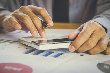İşadamı veya iş veri kavramı hesaplamak için hesap makinesi üzerinde çalışmaya muhasebeci. Muhasebe, mali rapor durumuna danışmanlık ve planlama ofisinde bir pazarlama planı yatırım danışmanı.