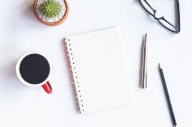 Bilgisayarlı beyaz masa ofisi, akıllı telefon ve bir fincan kahveli diğer iş malzemeleri. Metni kopyalamak için üst görünümü kullan. Desenci çalışma alanı düz masa üzerinde temel elementler yatıyordu.