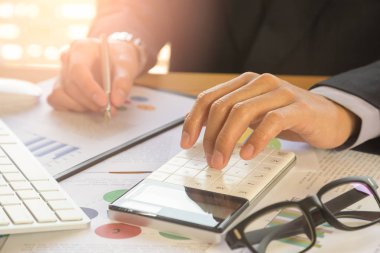 İşadamı veya otobüs hesaplamak için hesap makinesi üzerinde çalışmaya muhasebeci