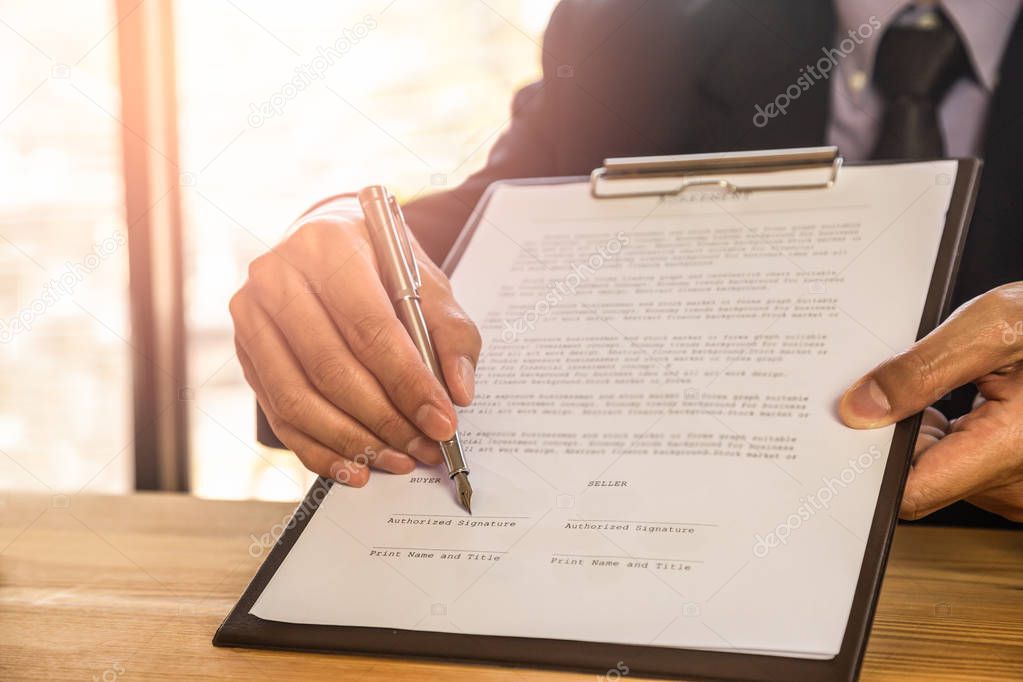 Business man signing a contract. Owns the business sign personal