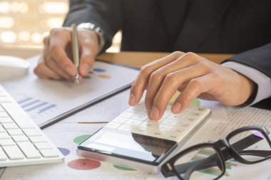 İşadamı veya otobüs hesaplamak için hesap makinesi üzerinde çalışmaya muhasebeci