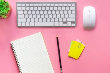 Dizüstü bilgisayarı, akıllı telefonu ve bir fincan kahveli diğer iş malzemeleri olan Pastel Pembe ofis. Metni kopyalamak için üst görünümü kullan. Çalışma alanı düz zeminde masa başı temel elementler üzerine.