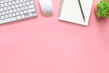 Dizüstü bilgisayarı, akıllı telefonu ve bir fincan kahveli diğer iş malzemeleri olan Pastel Pembe ofis. Metni kopyalamak için üst görünümü kullan. Çalışma alanı düz zeminde masa başı temel elementler üzerine.