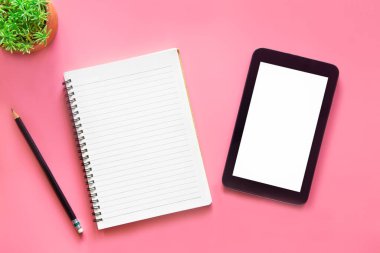 Dizüstü bilgisayarı, akıllı telefonu ve bir fincan kahveli diğer iş malzemeleri olan Pastel Pembe ofis. Metni kopyalamak için üst görünümü kullan. Çalışma alanı düz zeminde masa başı temel elementler üzerine.