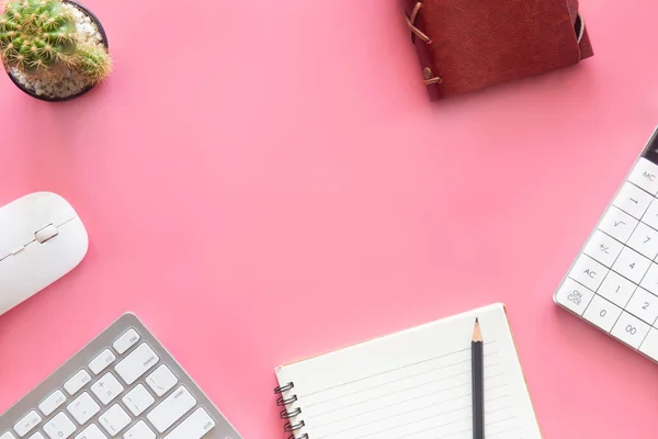 Pastel pink desk office with laptop, smartphone and other work supplies with cup of coffee. Top view with copy space for input the text. Workspace on desk table essential elements on flat lay.