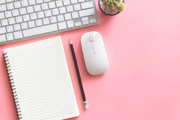 Pastel pink desk office with laptop, smartphone and other work supplies with cup of coffee. Top view with copy space for input the text. Workspace on desk table essential elements on flat lay.