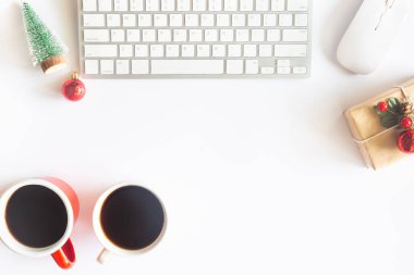 Beyaz Noel, dizüstü bilgisayarlı masa başı ofisi, dekorasyon ve bir fincan kahve ile iş malzemeleri. Metni kopyalamak için üst görünümü kullan. Kış Noel 'inde masa düzleşmişti. İş Tatili Konsepti.