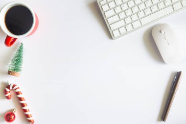 Beyaz Noel, dizüstü bilgisayarlı masa başı ofisi, dekorasyon ve bir fincan kahve ile iş malzemeleri. Metni kopyalamak için üst görünümü kullan. Kış Noel 'inde masa düzleşmişti. İş Tatili Konsepti.