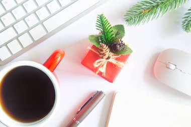 Beyaz Noel, dizüstü bilgisayarlı masa başı ofisi, dekorasyon ve bir fincan kahve ile iş malzemeleri. Metni kopyalamak için üst görünümü kullan. Kış Noel 'inde masa düzleşmişti. İş Tatili Konsepti.