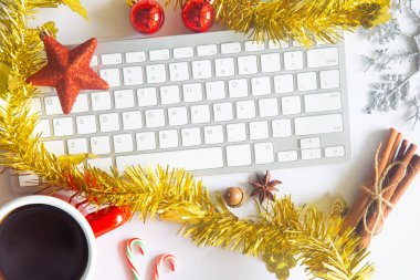 Beyaz Noel, dizüstü bilgisayarlı masa başı ofisi, dekorasyon ve bir fincan kahve ile iş malzemeleri. Metni kopyalamak için üst görünümü kullan. Kış Noel 'inde masa düzleşmişti. İş Tatili Konsepti.