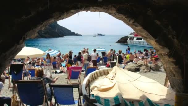 Old boathouse in the crowded little seaview beach of San Fruttuoso in italy seen from a stone arch — 图库视频影像