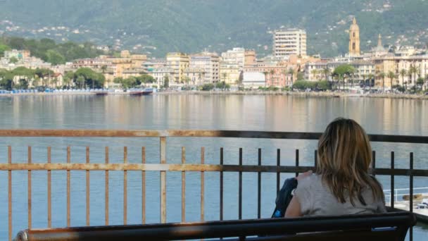 Mulher sentar banco cidade mar baía skyline visão traseira Rapallo italiano Riviera Itália — Vídeo de Stock