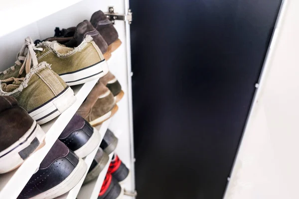 Zapatero de zapatillas zapatos cerca de estante —  Fotos de Stock