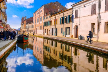 Comacchio vale Ferrara eyaletinin Emilia Romagna Bölgesi İtalya mavi gökyüzünde kanal üzerinde Bisiklete binme