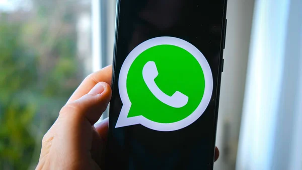 Uso de la mano Whatsapp aplicación símbolo en el teléfono inteligente — Foto de Stock