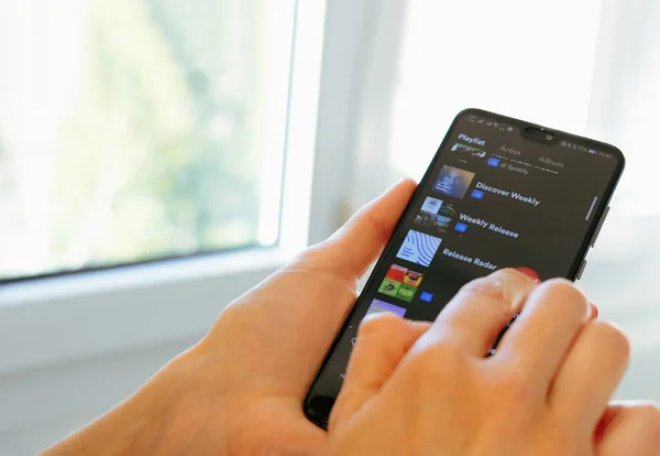Spotify music app hand smartphone playlist scrolling — Stock Photo, Image